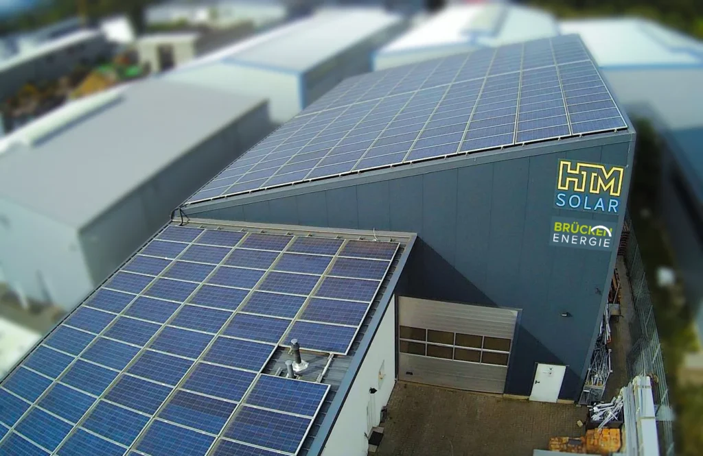 Ansicht der Gebäude von HTM Solar sowie Brücken Energie aus Euskirchen aus der Vogelperspektive. Die gesamten Dachflächen sind mit PV Anlagen von Brücken Energie aus Euskirchen ausgestattet.